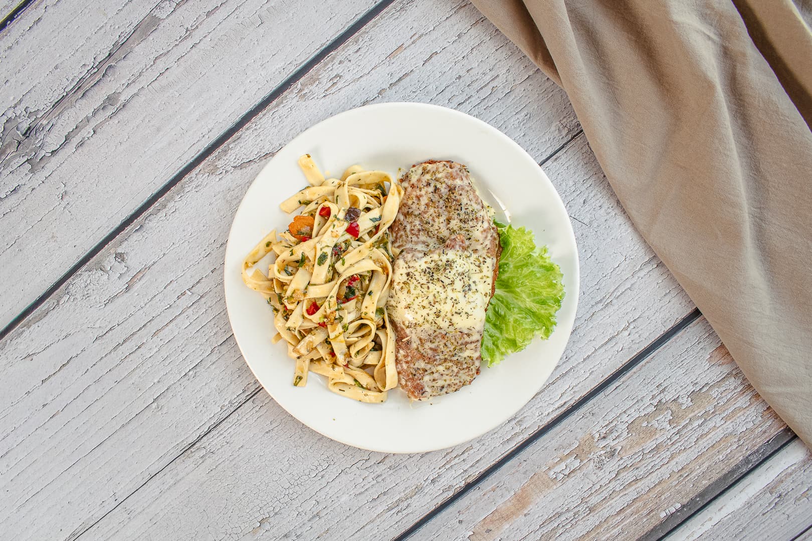 Milanesa de pollo gratinada con fideos cinta y verduras